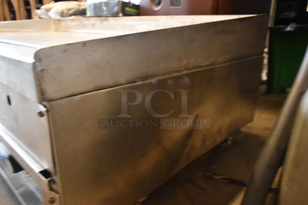 Stainless steel commercial kitchen equipment, rectangular, with visible wear and minor scratches, no visible labels.