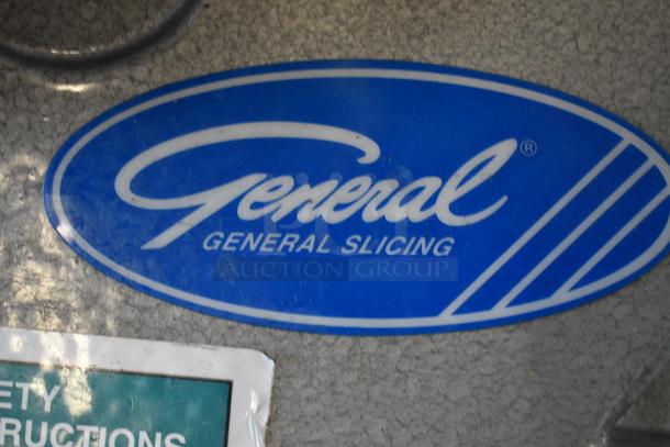 Blue "General Slicing" logo on metal surface, minor wear; safety instructions partially visible.