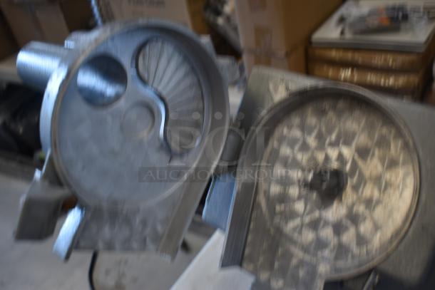 Abstract metal sculpture with circular and fan-like designs, showing industrial craftsmanship. Surfaces appear worn, possibly used.