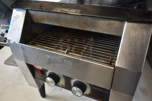 Commercial stainless steel toaster, two control knobs, "Caution Hot" label. Used condition, signs of wear.