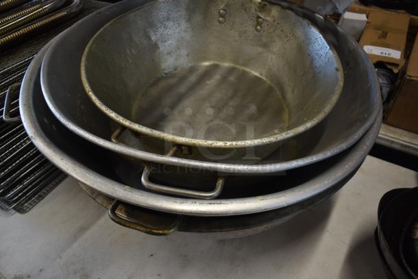 Stacked metal tubs with handles, showing signs of wear and patina, ideal for vintage decor or industrial use.