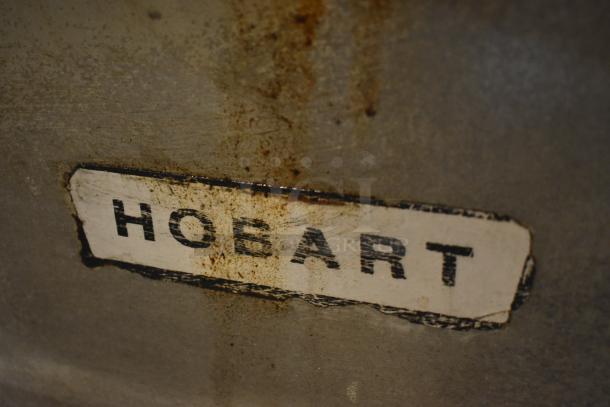Rusty vintage Hobart appliance with a worn label showing brand name, indicating potential collectible value.