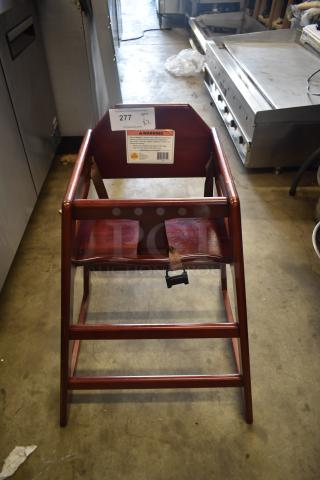 Wooden high chair with dark finish, safety harness included. Good condition with visible warning label and auction tag "277".