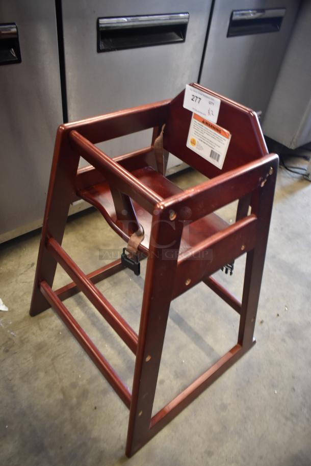 Wooden high chair with safety strap, lot tag "277 K2." Good condition, ideal for restaurants. Safety warning label visible.