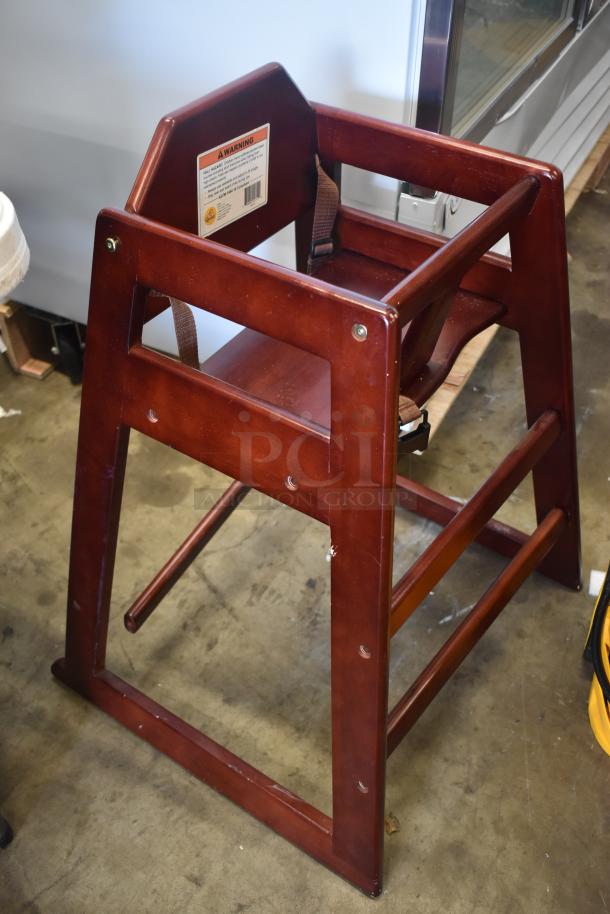 Wooden high chair with safety straps, dark finish, minor scuffs. Warning label on back. Sturdy construction.