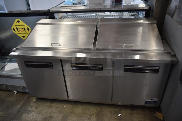 Commercial stainless steel sandwich prep table with double doors, Yukon brand, gently used condition, visible storage shelves.