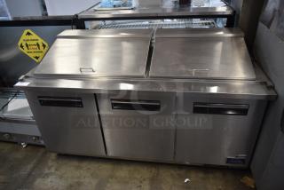 Commercial stainless steel sandwich prep table with double doors, Yukon brand, gently used condition, visible storage shelves.