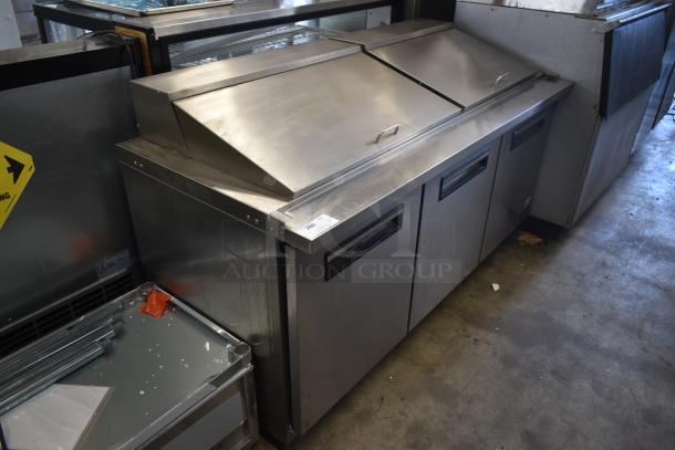 Stainless steel commercial countertop refrigerator with three doors, pull handles, and top covers. Tag number 280 visible.