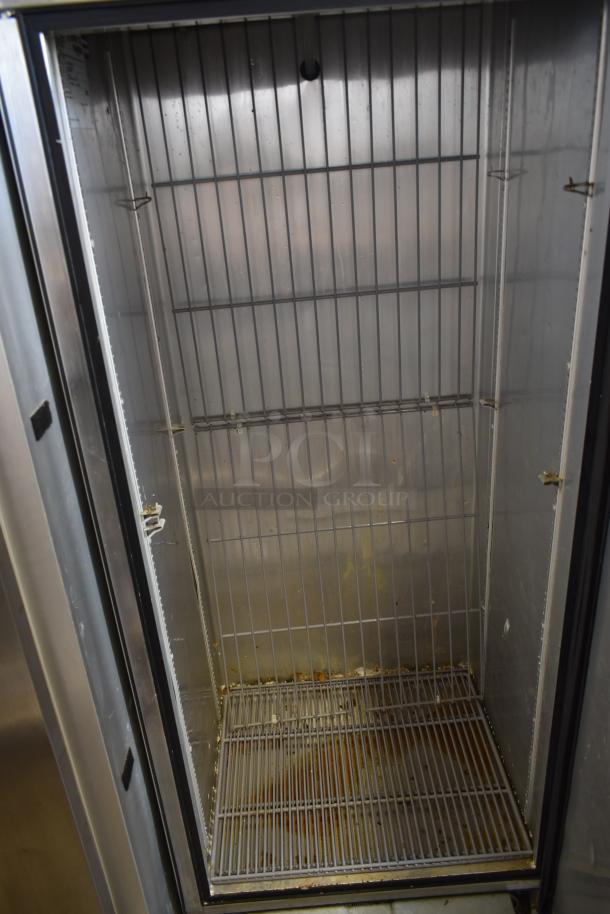 Used commercial refrigerator interior with wire shelves and slight rust on the bottom shelf. No visible brand or labels.