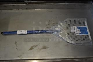 Blue and silver pizza paddle, new in packaging, labeled "284" for auction. Perforated design with barcode visible.
