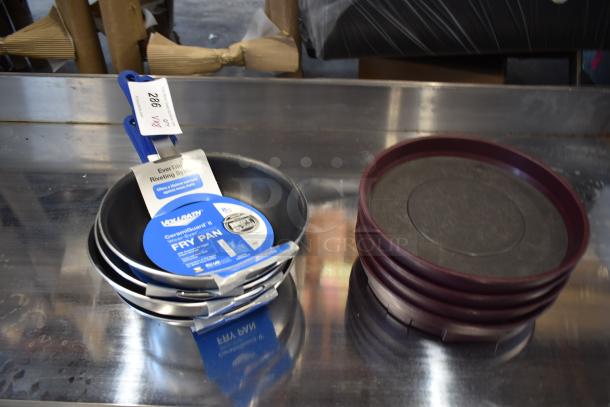 Set of new Vollrath CeramicGuard II fry pans with blue handles and labels, next to stack of maroon trays.