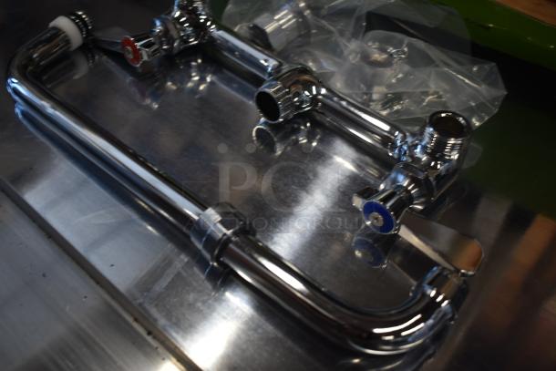Chrome-plated plumbing fixture set, new condition with red and blue temperature handles, shown on a metallic surface.