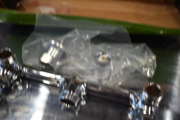 Blurred image of a chrome plumbing fixture with plastic wrapping, unclear condition and details.