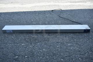 Rectangular metal light fixture with power cord, caution marking visible, tag labeled "290." Good condition.