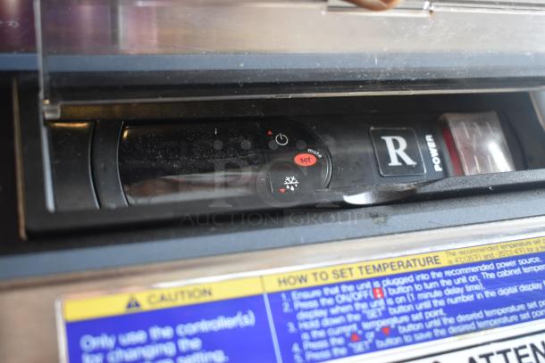 Close-up of a control panel with "R" power button, temperature settings, and instructions for operation. Dust on surface.