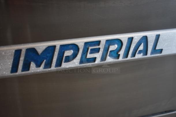 Close-up of "IMPERIAL" logo on stainless steel appliance, highlighting blue embossed lettering. Clean and well-maintained surface.
