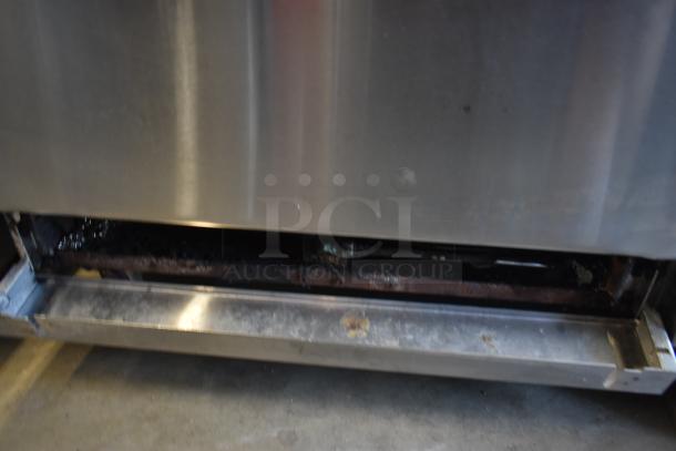 Stainless steel commercial appliance with visible lower compartment, signs of rust and wear, suitable for repair or parts.