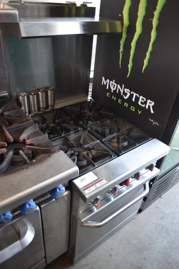 Commercial stainless steel stove with six burners, oven, and metal dials. Number "293" tag displayed. Some rust visible.