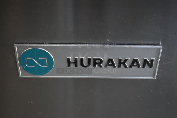 Hurakan appliance logo on a stainless steel surface, featuring a turquoise emblem. No visible damage or wear.