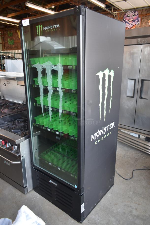 Monster Energy branded beverage cooler with glass door, green shelving, and logo graphics. Black exterior, good condition.