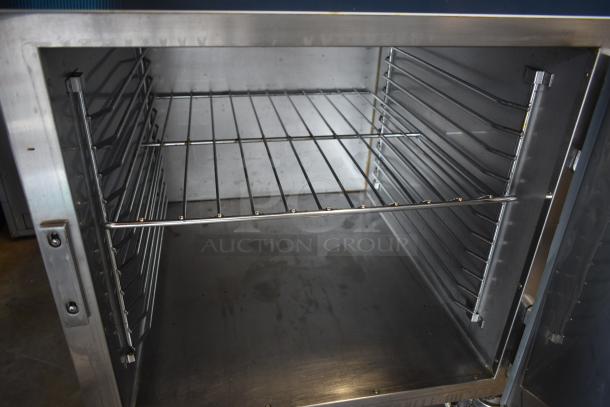 Commercial stainless steel oven interior with rack slots, showing minor wear. Ideal for restaurant or bakery use.