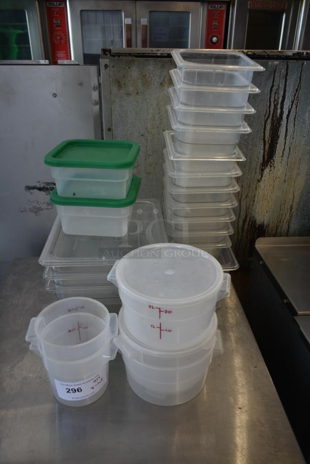Stack of clear plastic storage containers with green lids and measuring markings. Includes a 2-quart marked container with auction label 296.