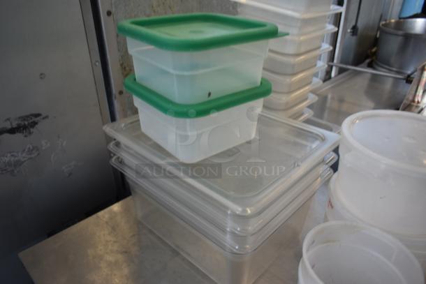 Stack of clear and opaque food storage containers with green lids. Various sizes, used condition.