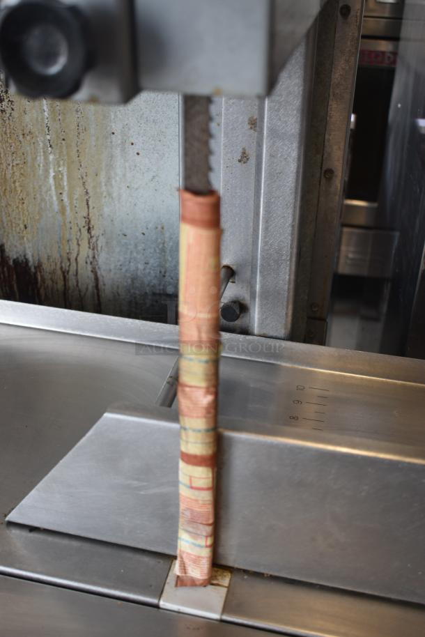 Industrial meat slicer with wrapped blade, stainless steel, measuring scale visible, used condition.
