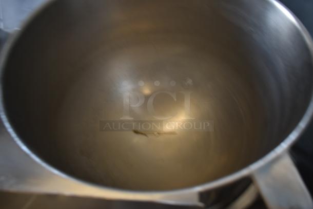 Large stainless steel pot with handles, showing light interior wear, suitable for commercial kitchen use. No visible markings.