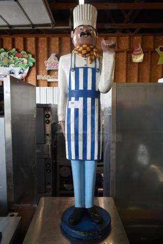 Vintage chef statue with striped apron and hat, holding a plate. Shows wear, numbered tag "300." Ideal for decor.