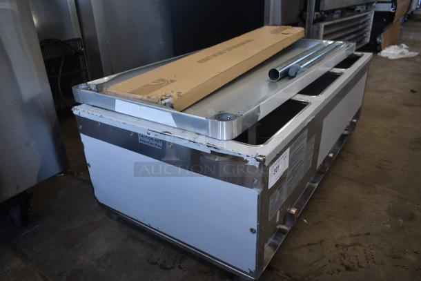 Commercial stainless steel food warmer, used condition, visible wear. Caution label indicates heat. Includes cardboard package and metal tubes on top.