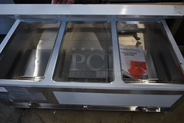 Stainless steel three-compartment warming tray with open lid. Includes instruction manual and red parts inside. Good condition.