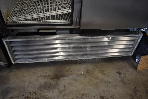 Commercial metal vent, featuring horizontal slats and signs of wear, possibly part of a refrigeration unit; no tags visible.