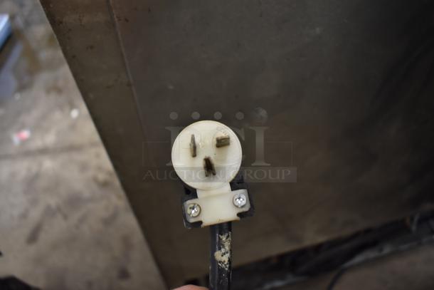 Three-prong electrical plug with "Leviton" marking, used condition, visible wear, suitable for auction.