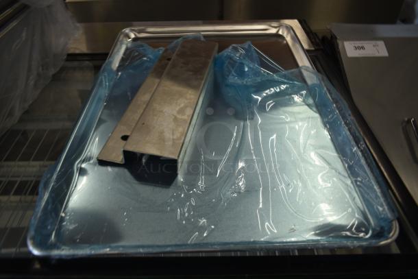 Stainless steel serving tray with a protective blue coating, includes metal divider. New condition. Lot number 306 visible.