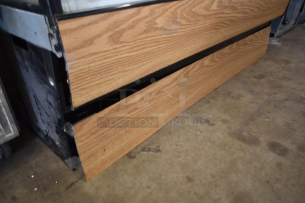 Commercial display case base with wood paneling and metal frame. Visible wear on metal edges, suitable for retail use.