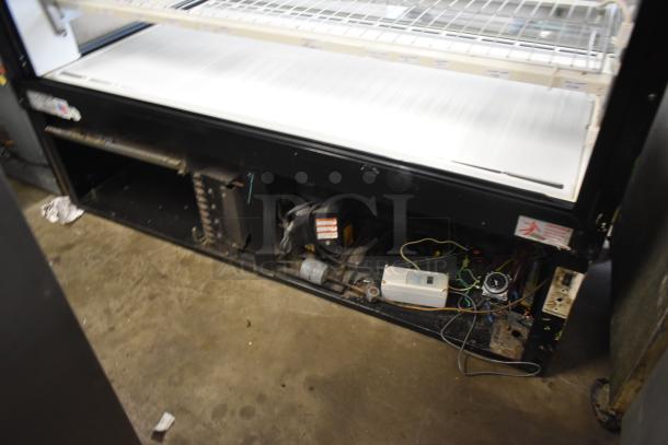 Commercial refrigerator display case with visible wiring and mechanical components. Needs maintenance. Minor wear visible.