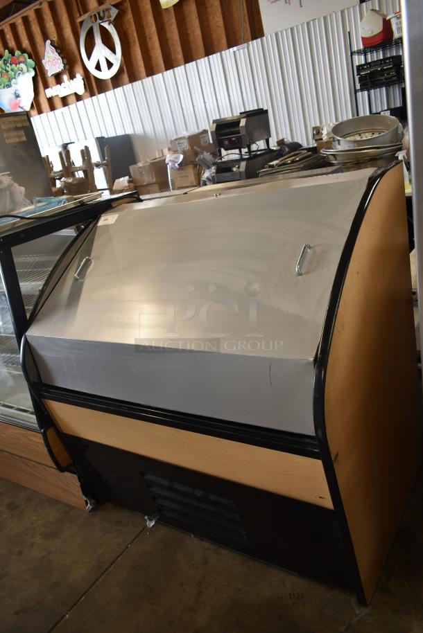 Commercial refrigerated display case with curved glass, stainless steel top, and wood accents. Used condition.