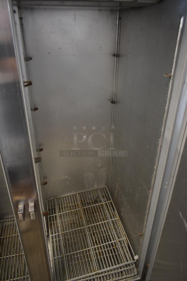Stainless steel commercial refrigerator interior, showing wire racks, some rust and discoloration. Used condition.