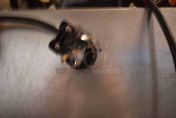 Blurry close-up of a black electrical plug with exposed wires. Condition unclear due to image quality.