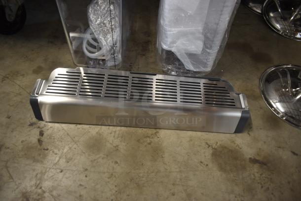 Stainless steel grill vent cover, new condition, features slotted design, suitable for kitchen or appliance use.