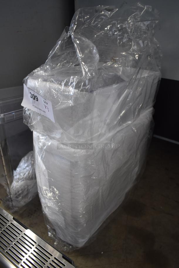 Large commercial kitchen equipment covered in plastic wrap, auction tag number 309 from PCI Auctions visible.
