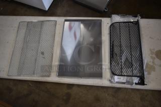 Metal wire mesh trays and a reflective metal sheet displayed on a table. Items appear in good condition; tag number 312 visible.