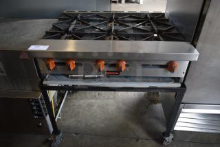 Commercial countertop gas stove with six burners and orange control knobs. Sierra brand. Item tag "315" visible.