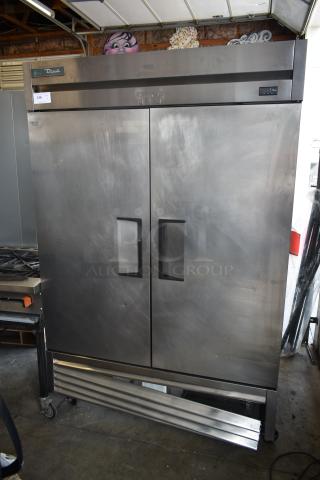 True double-door commercial refrigerator in stainless steel, used condition, model T-49F, visible wear and tear, suitable for restaurant use.