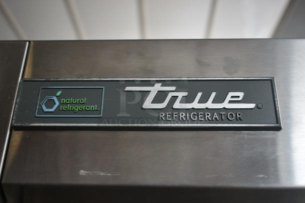True Refrigerator stainless steel front panel with "natural refrigerant" label, indicating eco-friendly cooling.