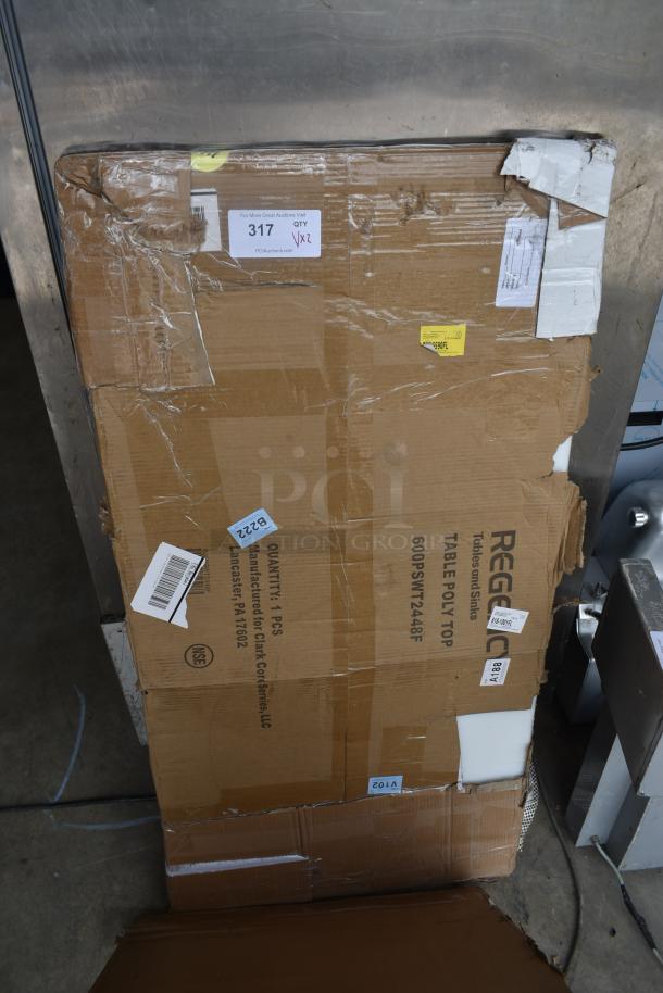 Cardboard box labeled "Regency Table Poly Top," showing signs of wear. Various stickers with shipping information are attached.