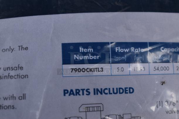 Close-up of a product label showing item number 7900CKITL3 with a flow rate of 5.0 gpm and capacity of 54,000 gallons.