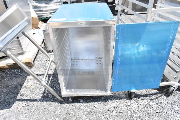 Stainless steel mobile cabinet on wheels, open door, blue protective film, interior shelving slots, excellent condition.