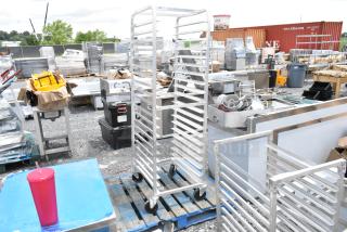 Metal bakery rack on wheels with multiple shelves, used condition, suitable for commercial kitchens.